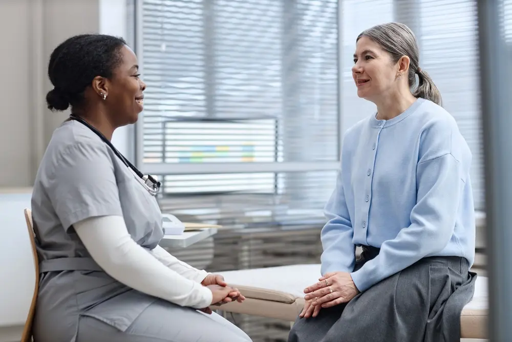 Female doctor wearing a stethoscope consulting with a male patient about comprehensive medical care