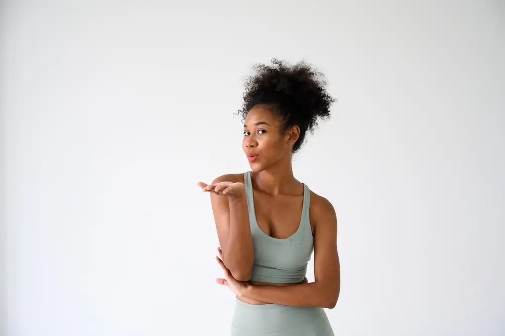 Smiling woman in white workout clothes representing reproductive health care