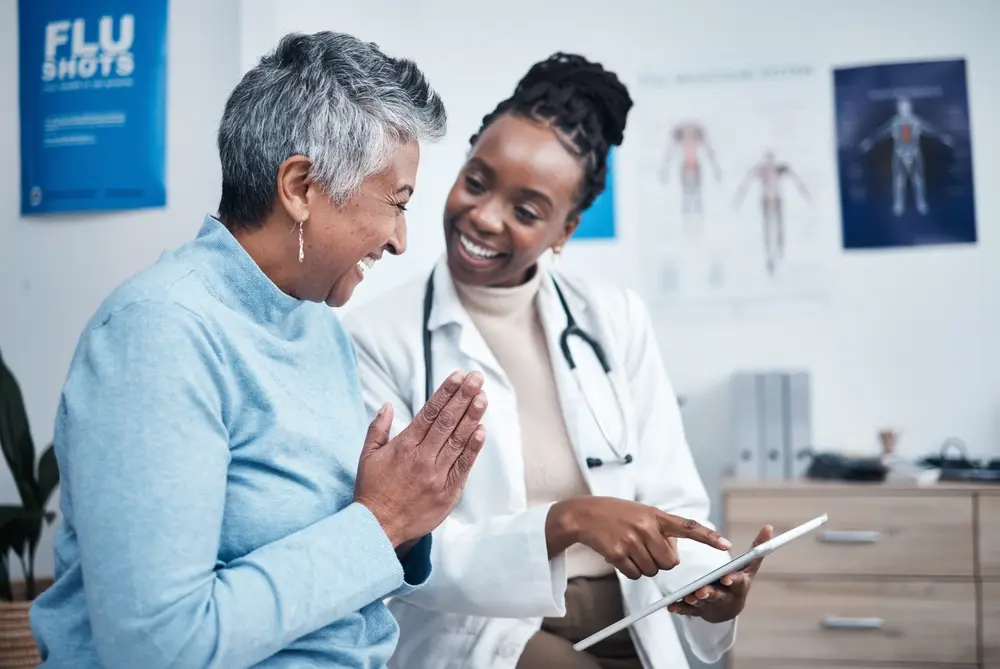 Female primary care doctor wearing a stethoscope consulting with a male patient