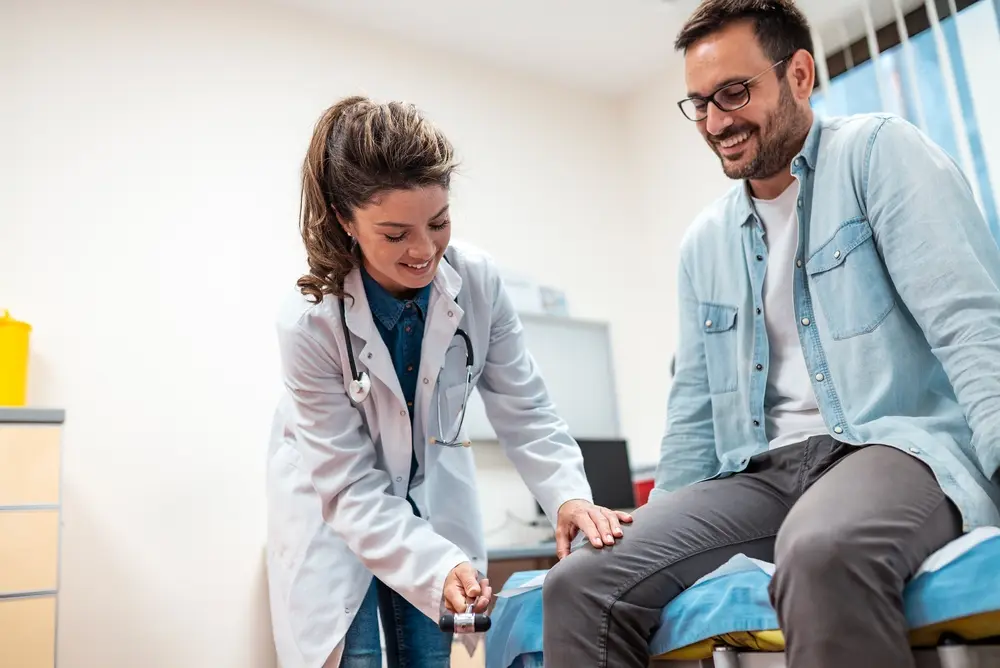 Female doctor discussing immigration health exam costs with a male patient