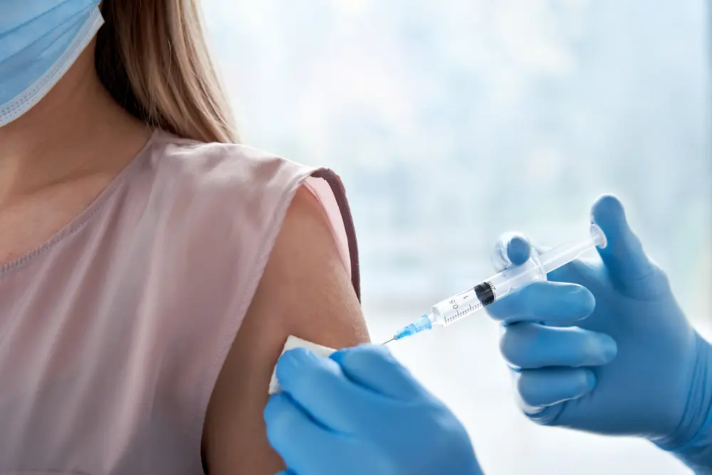 Female doctor reviewing vaccination records for an immigration health screening