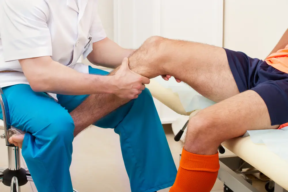 Physician reviewing sports participation forms with an athlete and parent in Royal Palm Beach