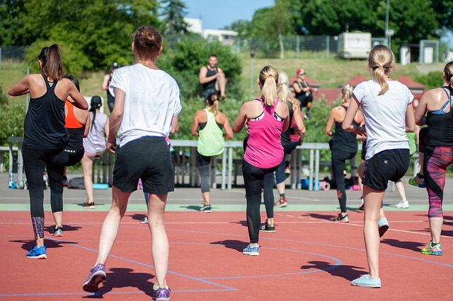 Students exercising in an open field during sports physical preparation