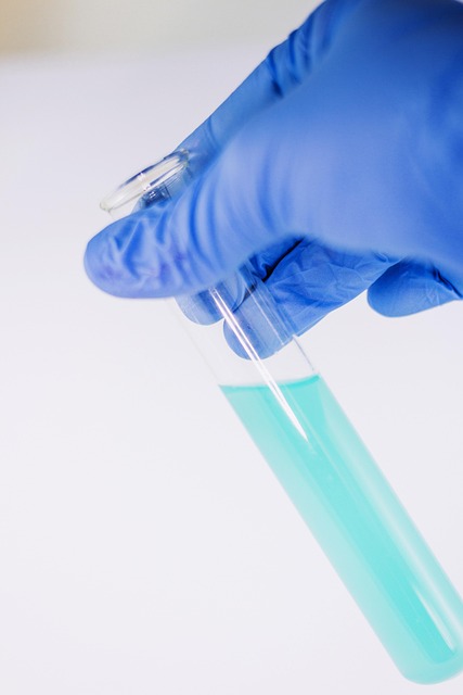 Gloved hand holding a test tube filled with blue liquid for Suboxone treatment