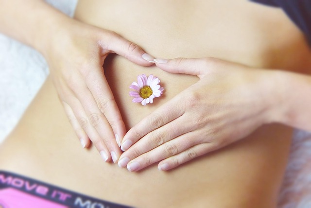 Woman lying on her back with a flower on her belly for women’s health care